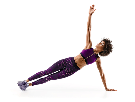 Strong girl doing fitness plank position exercises. Photo of african girl in silhouette on white background. Fitness and healthy lifestyle conceptの写真素材