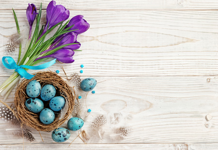 Easter background with Easter eggs and spring flowers. Top view with copy space.の写真素材