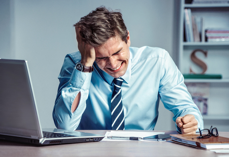 Crying man. Worker dissatisfied his earnings. Photo of young man working in the office. Business conceptの写真素材
