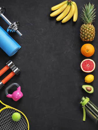 Sports equipment and organic food on black background. Top view. Motivationの写真素材