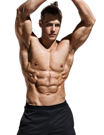 Sporty man showing off his muscular physique and six pack abs. Photo of young man with perfect body after training on white background. Strength and motivationの写真素材