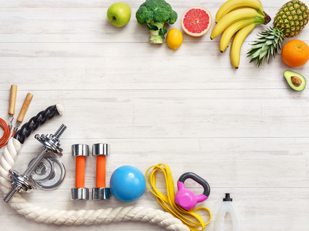 Sports equipment and healthy food on a white wooden background. Top view. Motivationの写真素材