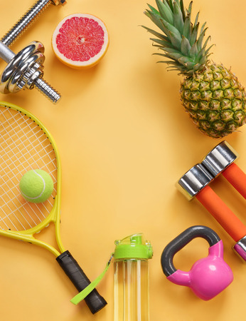 Sports equipment and organic food on yellow background. Top view. Motivationの写真素材