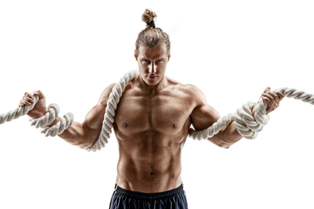 Strong muscular man working out with heavy ropes. Photo of young man shirtless isolated on white background. Strength and motivationの写真素材