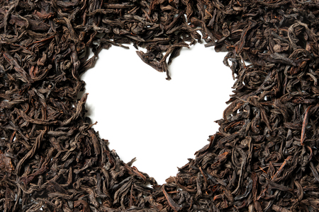 Heart shaped from black leaf tea on white background. Top view. Close up. High resolutionの写真素材