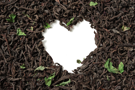 Heart shaped from black tea with mint leaves on white background. Top view. Close up. High resolutionの写真素材