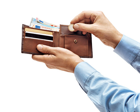 Man's hands in shirt putting a coin in the wallet isolated on white background. High resolution...