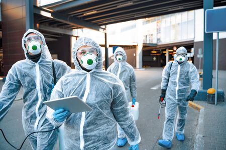 Healthcare workers wearing hazmat suits working together during an outbreak in the cityの写真素材