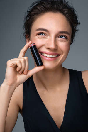Woman with lipstick. Photo of woman with perfect makeup on gray background. Beauty conceptの写真素材
