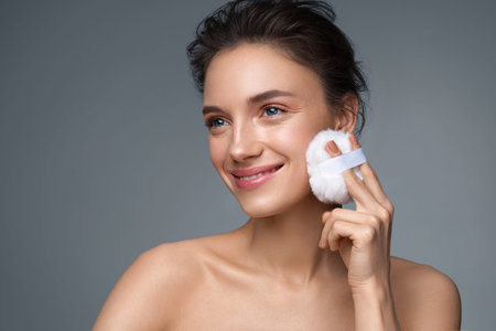Beautiful woman applying dry powder, using cosmetic cushion on her facial skin. Photo of woman with...