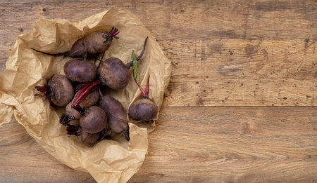 Beets in paper packaging on old wooden tableの写真素材