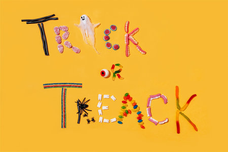 Trick or treat. Sweet candy on yellow background. halloween partyの写真素材