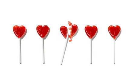 Heart-shaped lollipops among them, one is broken into pieces isolated on white background. Valentine's day. holiday backgroundの写真素材
