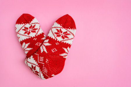 Knitted socks folded in the shape of heart on pink background. Valentine's day. Holiday backgroundの写真素材