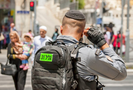 JERUSALEM, ISRAEL. June 20, 2017. Israel border police guard fixing earphone by the Damascus gate,...