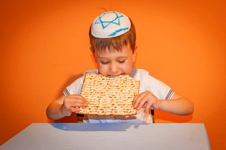 Happy little Jewish child with a kippah on his head looking forward for the Jewish holiday of Pessach. Passover illustration.の写真素材