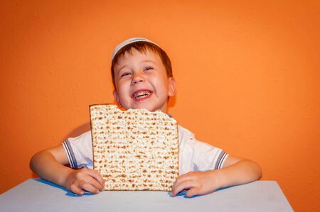 Happy little Jewish child with a kippah on his head looking forward for the Jewish holiday of Pessach. Passover illustration.の写真素材