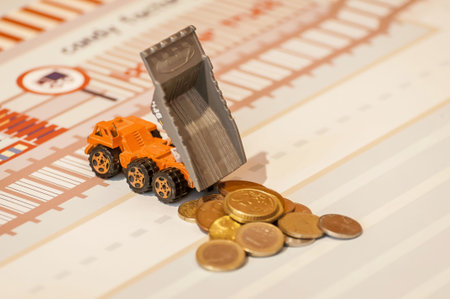 Orange toy truck unloading coins, money concept, expense, lottery, financial gain, benefit, dividend...