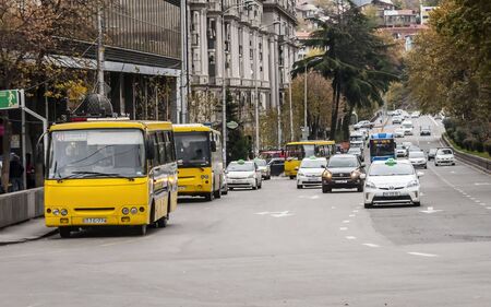 TBILISI, GEORGIA. November 23, 2019. A typical yellow route commuter buses parked on a bus stop in central Tbilisi.のeditorial素材