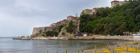 Folded umbrellas on the beach, on the mountain of old buildings hotelsのeditorial素材