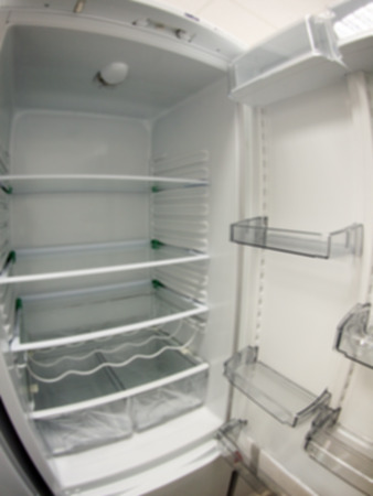 Defocused and blurry image of an open empty white refrigerator with wide angle distortion viewの写真素材
