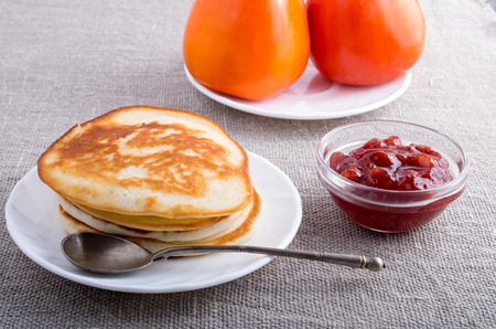 Ingredients for breakfast. Hot pancakes, strawberry jam and tomatoes close-up on a gray background textileの写真素材
