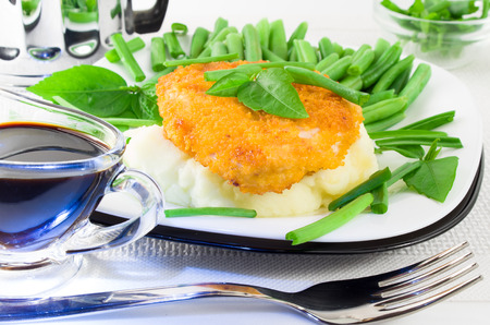 Close-up view of fried chicken, mashed potatoes and green beans with leekの写真素材