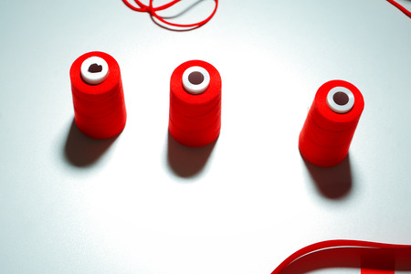 Accessories for sewing lie on a white background. Measuring tape, thread, fabric and needles .の写真素材