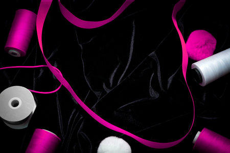 threads, ribbons on a black, pink, magenta, background