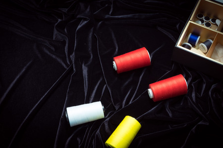 threads, ribbons on a black, red, backgroundの写真素材