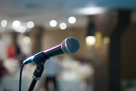 Microphone in concert hall or conference room with defocused bokeh lights in background. Extremely shallow dof. : Vintage style and filtered processの写真素材