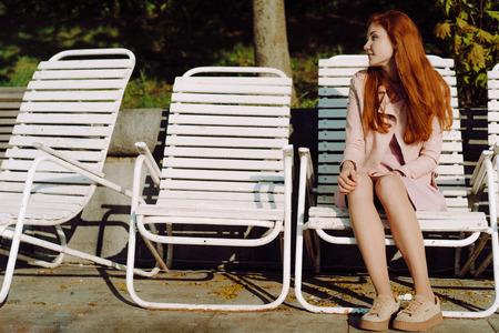Beautiful red-haired girl in the parkの写真素材