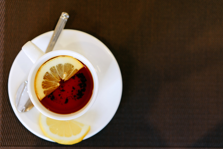 cup of tea with lemon on a brown backgroundの写真素材