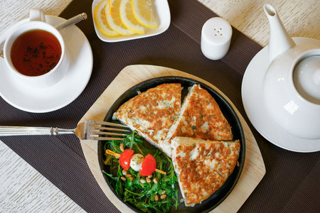 A healthy breakfast, scrambled eggs, tea, cheese, butter, fresh herbs. Top view, close-up. Healthy food.の写真素材
