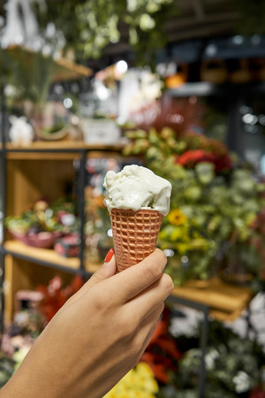 female hand holding vanilla ice creamの写真素材