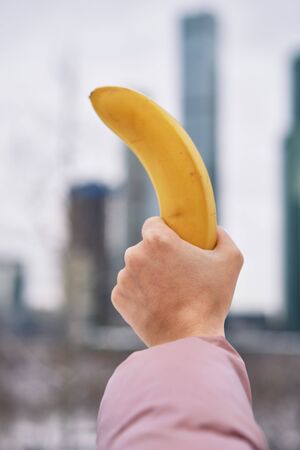 banana in hand on the background of the city the girlの写真素材