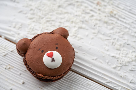 macaroon in the shape of a bear on a white wooden background