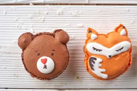macaroon in the shape of a bear on a white wooden background