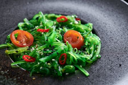 Chuk salad in a glass plate close-up on a black background.の写真素材