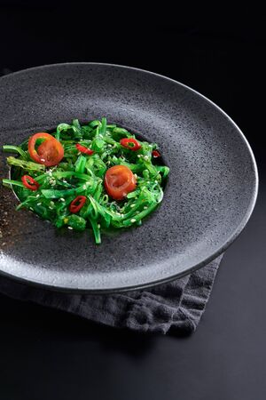 Chuk salad in a glass plate close-up on a black background.の写真素材