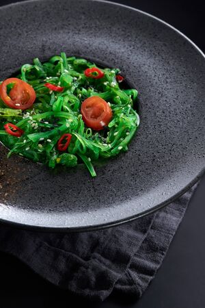 Chuk salad in a glass plate close-up on a black background.の写真素材