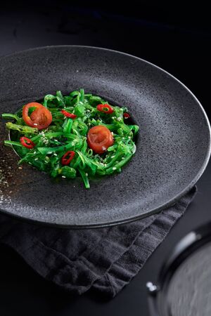 Chuk salad in a glass plate close-up on a black background.の写真素材