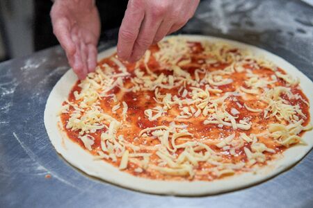 the chef in the kitchen prepares pizzaの写真素材