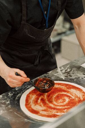 the chef in the kitchen prepares pizzaの写真素材