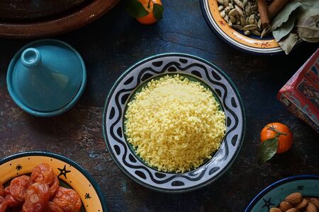 Bulgur porridge in a painted Eastern plate in the center of the table Mandarin dried apricots Eastern cuisineの写真素材