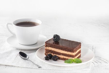 Delicious chocolate cake in white plate on white wooden table background, closeupの写真素材