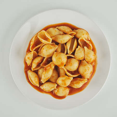 pasta on a white plate with tomato sauceの写真素材