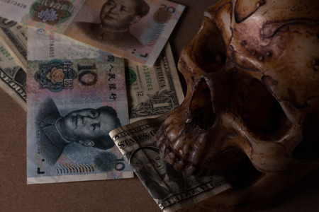 skull on old wood with banknote yuan and dollar in still-lifeの写真素材