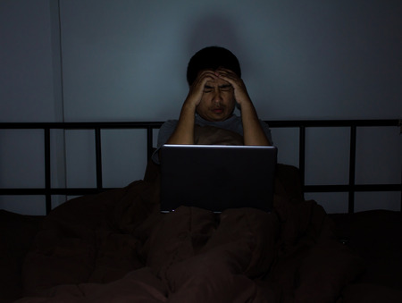 Youngman At Bedroom On Bed Working On Laptopの写真素材