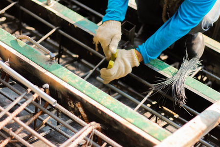 worker installing steel column on scaffolding in construction site